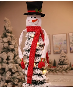 Close-up of a snowman Christmas tree topper with a black hat and red polka dot scarf