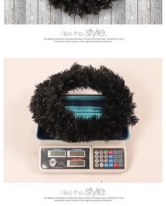 Detail shot of a black PVC sequin wreath on a scale showing a weight of 0.340kg