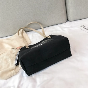 Black canvas tote bag with beige leather handles and AWL print in a lifestyle setting