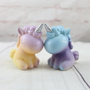 Gros plan de décorations de gâteau licorne mignonnes en dégradé de bleu, violet et jaune