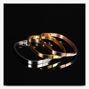 Macro detail of three-tone stainless steel bangles with brushed metal finish and double row crystals