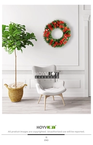 Gros plan d'une couronne de Noël verte avec des nœuds rouges sur un mur blanc