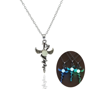 Luminous dragon cross pendant showing glowing effect in the dark and silver finish detail