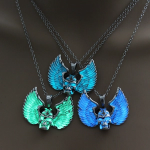 Detailed view of three skull wing necklaces with glowing effects in dark environment