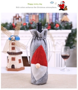 Detail of Christmas gnome wine bottle cover in gray felt with red knitted gnome decor
