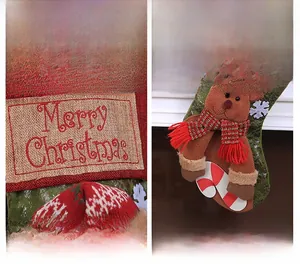 Detail of red knit Christmas stocking with reindeer embroidery and Merry Christmas text