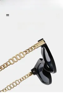 Close-up of golden metal chain temple and hinge on vintage black cat-eye sunglasses