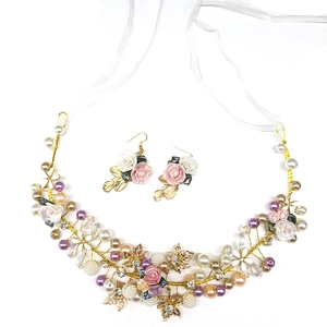 Detail of bridal hairband and earrings set with ceramic flowers, pearls and gold wire