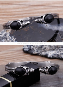 Dettaglio del bracciale punk vintage con teschi doppi e pietre preziose nere