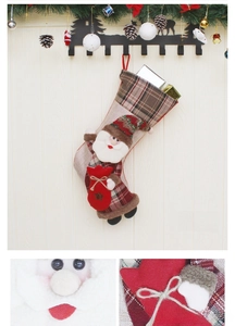 Détail d'une chaussette de Noël avec figurine Père Noël 3D et motif à carreaux festif