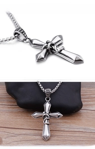 Detail of vintage cross pendant with snake texture and rugged box chain for men
