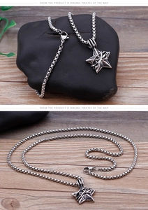 Detail of vintage silver star pendant with box chain on dark stones and wooden background