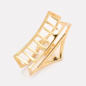 Close-up of golden hollow geometric metal hair claw clip with a polished finish