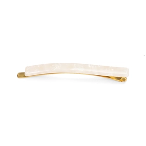 Detail of minimalist cream acetate hair clip with golden metal base and pearl texture