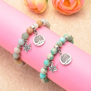 8mm Amazonite and Turquoise yoga bracelets with Tree of Life charms on a pink stand