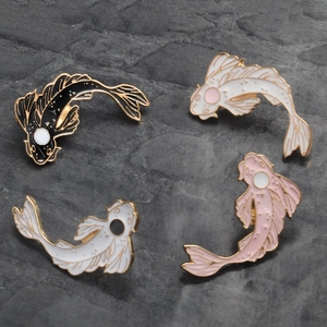 Set of four colorful koi fish enamel pins with gold metal borders on a stone background