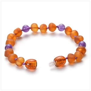 Detailed macro of baby amber bracelet with matte orange beads and purple amethyst accents