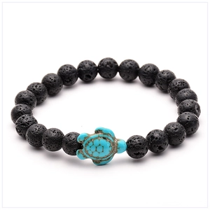 Close-up of black lava rock beads and a turquoise turtle charm on an elastic bracelet