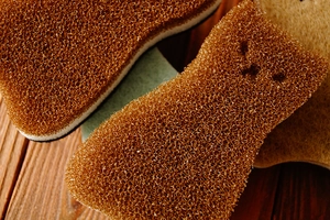 Macro shot of brown cat-shaped scrubbing sponge with high porosity cleaning texture