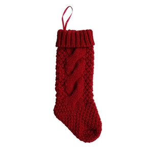Close-up of red cable knit Christmas stocking with festive hanging loop and textured wool