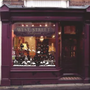 Christmas window decals with white town skyline, red snowflakes and Santa's sleigh
