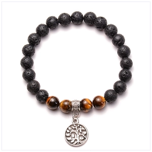 Detail of lava rock and tiger eye beads bracelet with a silver tree of life charm