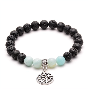 Macro detail of porous black lava stone beads and turquoise with silver tree of life charm