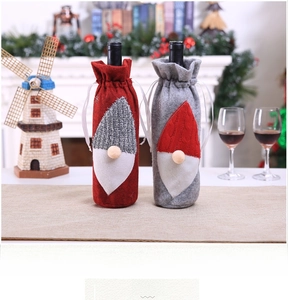 Detail of red and grey gnome wine bottle covers with white beards for Christmas table decor