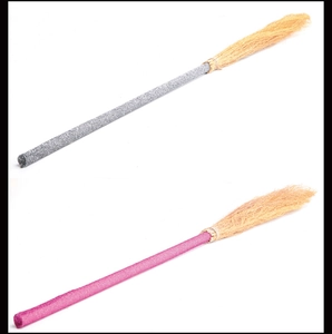 Macro detail of silver and pink glitter witch broom props for Halloween costumes