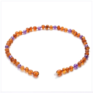 Detail of amber and purple amethyst beads on baby teething necklace with twist clasp
