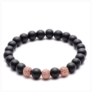 Macro shot of 8mm matte black agate beads with micro-paved rose gold zircon accents