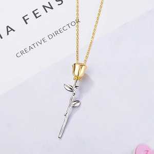 Minimalist rose pendant necklace featuring gold bud and silver stem on a thin chain