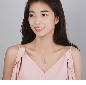 Close-up of a two-tone rose flower pendant necklace worn by a model on a gold chain