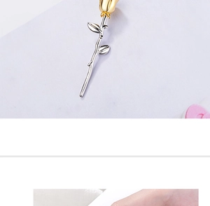 Detalle del colgante de rosa bicolor en oro y plata con un acabado metálico pulido