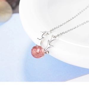 Macro shot of silver deer antler necklace featuring a pink strawberry quartz pendant