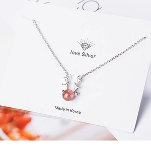 Close-up of antler pendant with strawberry crystal on silver necklace for women