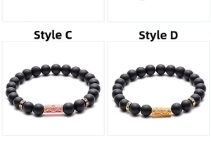 Detail of matte black stone bracelets with gold and rose gold hollowed tube beads
