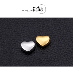 Macro shot of silver and gold heart-shaped stainless steel beads for DIY jewelry making