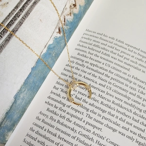 Close-up of a 925 sterling silver moon pendant with zircons on a vintage book page