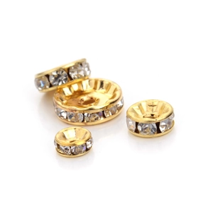Macro detail of gold-plated wave edge rhinestone spacers for DIY jewelry making