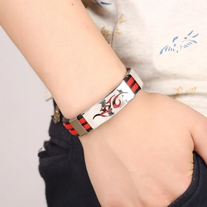 Macro detail of men's silicone wristband with fire pattern and Greek key metal accent