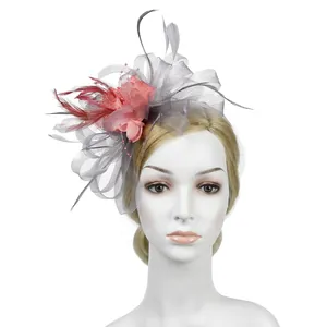 Detail of pink and grey mesh fascinator with red feathers and pearls for weddings