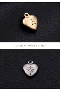 Macro detail of heart-shaped steel pendants with sunburst engraving on black leather