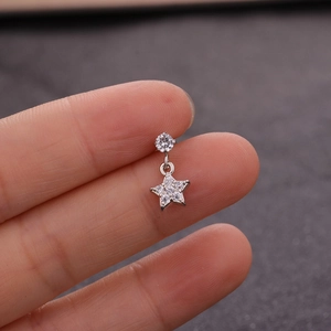 Silver star earring with zircon stone displayed on a finger for size perspective