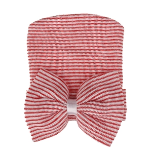 Detailed knit texture of red and white striped baby hospital hat with a large bow