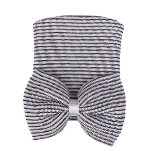 Close-up of baby hospital hat with black and white stripes and a large soft knit bow