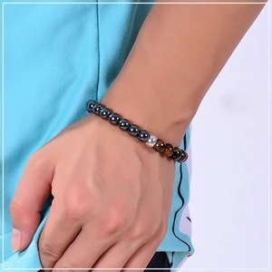 Macro shot of 8mm tiger eye and hematite stone beads on an elastic bracelet