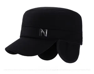 Detail of black winter military cap featuring ear flaps and metal letter N decoration
