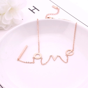 Elegant rose gold LOVE letter pendant necklace in titanium steel on a white ceramic plate