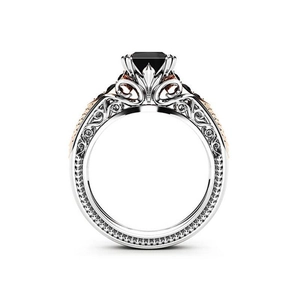 Detail of gothic style ring featuring emerald-cut black stone and rose gold filigree